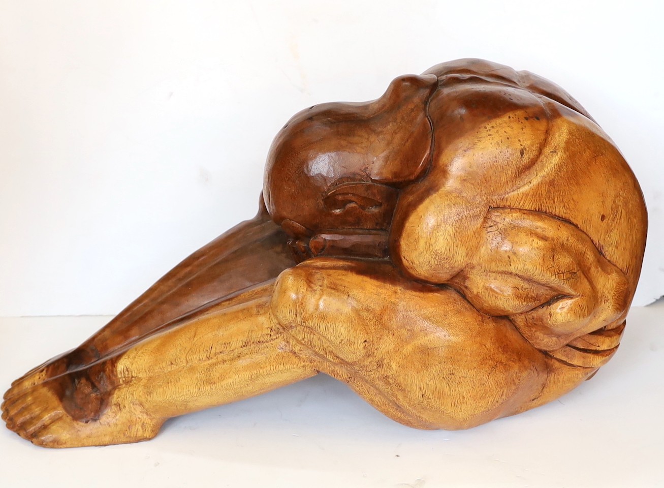 A Malaysian carved hardwood figure of the weeping Buddha, length 60cm. height 26cm